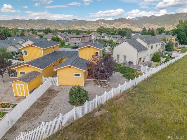 an aerial view of residential houses with outdoor space and ocean view