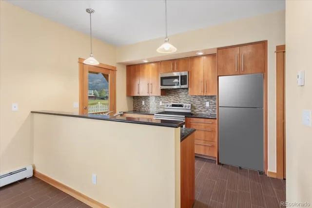 a kitchen with a refrigerator a stove top oven a large window and a refrigerator