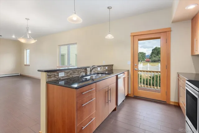 a kitchen with stainless steel appliances granite countertop a stove and a wooden floor