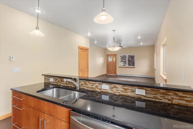 a kitchen with stainless steel appliances granite countertop a sink a counter space and cabinets