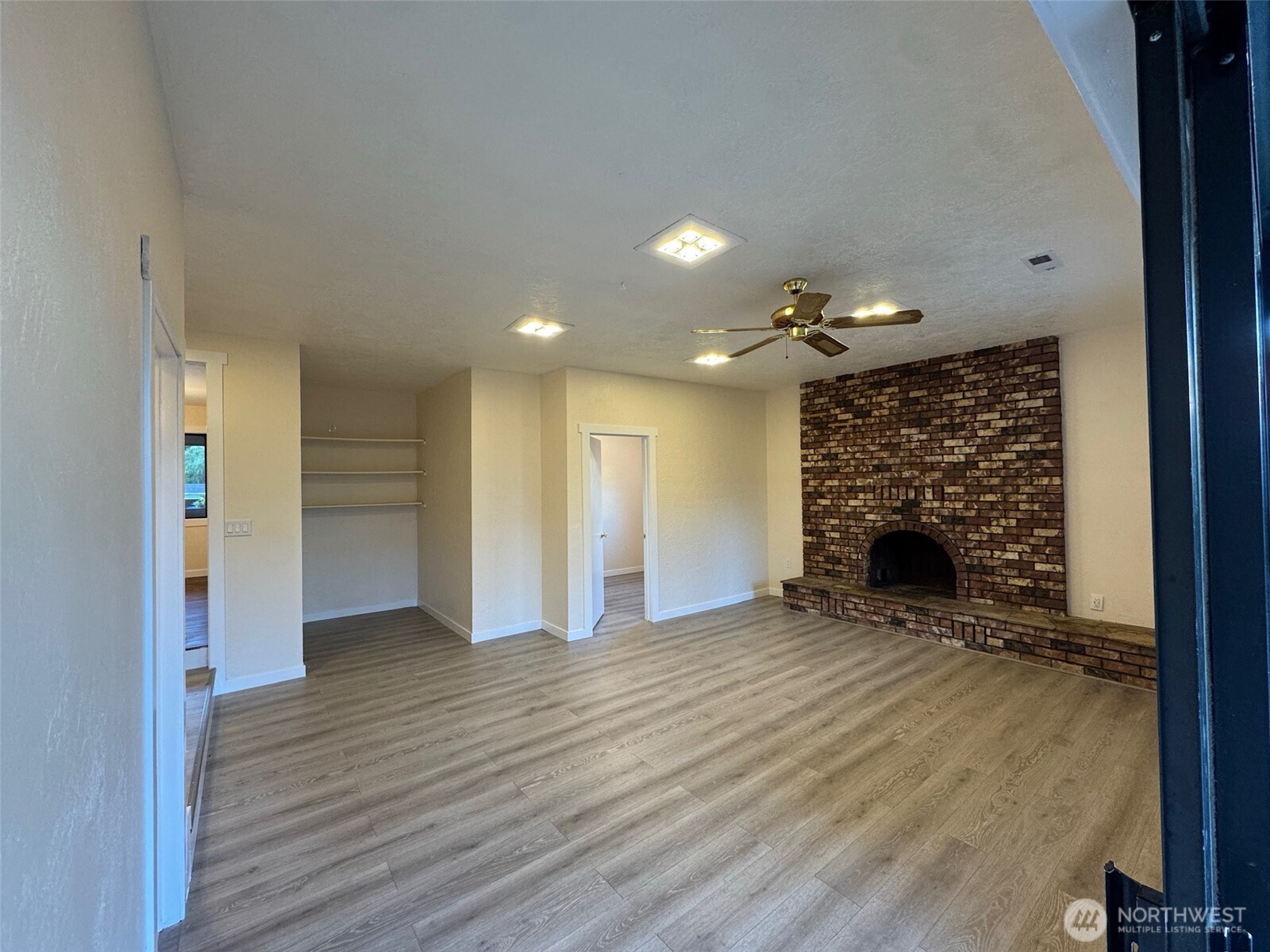 500 Mill Creek Road Southeast Shelton, WA 98584 - Photo 32 of 39 an empty room with wooden floor fireplace and windows