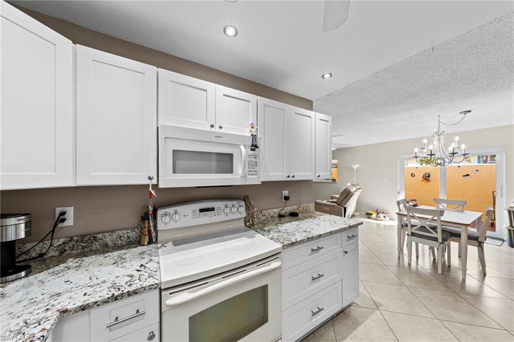 180 Harrison Road, Unit G4 Naples, FL 34112 - Photo 11 of 46 a kitchen with granite countertop a sink stove and cabinets