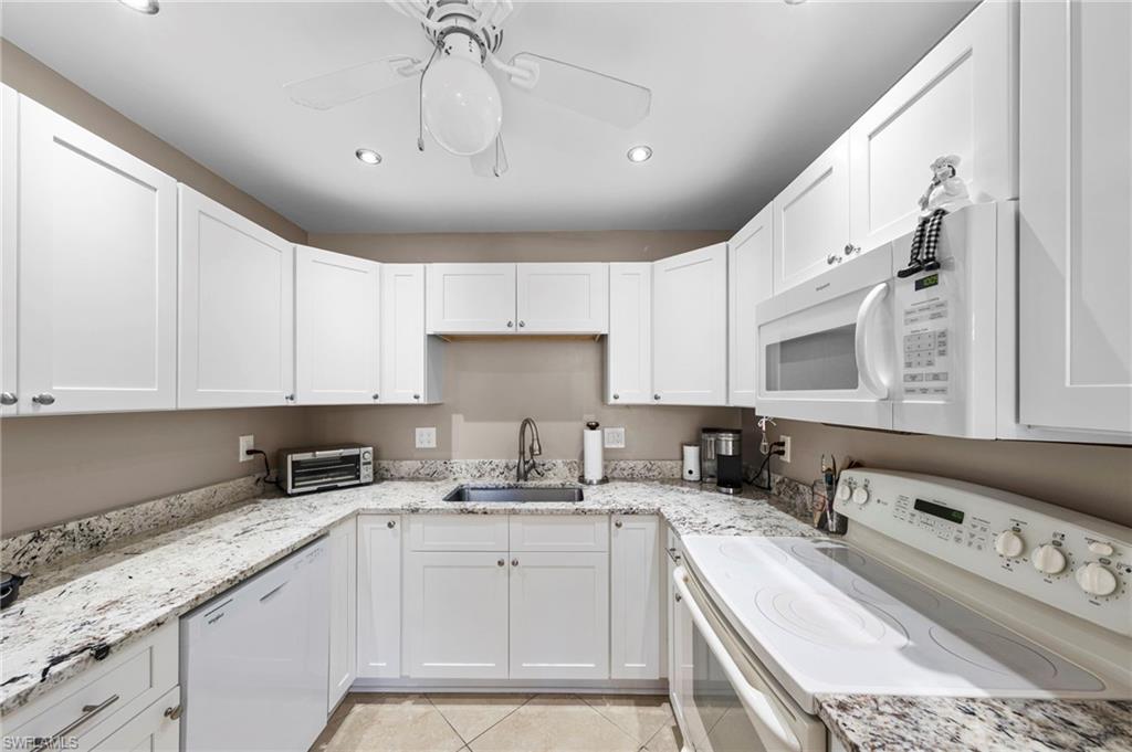 180 Harrison Road, Unit G4 Naples, FL 34112 - Photo 13 of 46 a kitchen with stainless steel appliances granite countertop a sink a stove and cabinets
