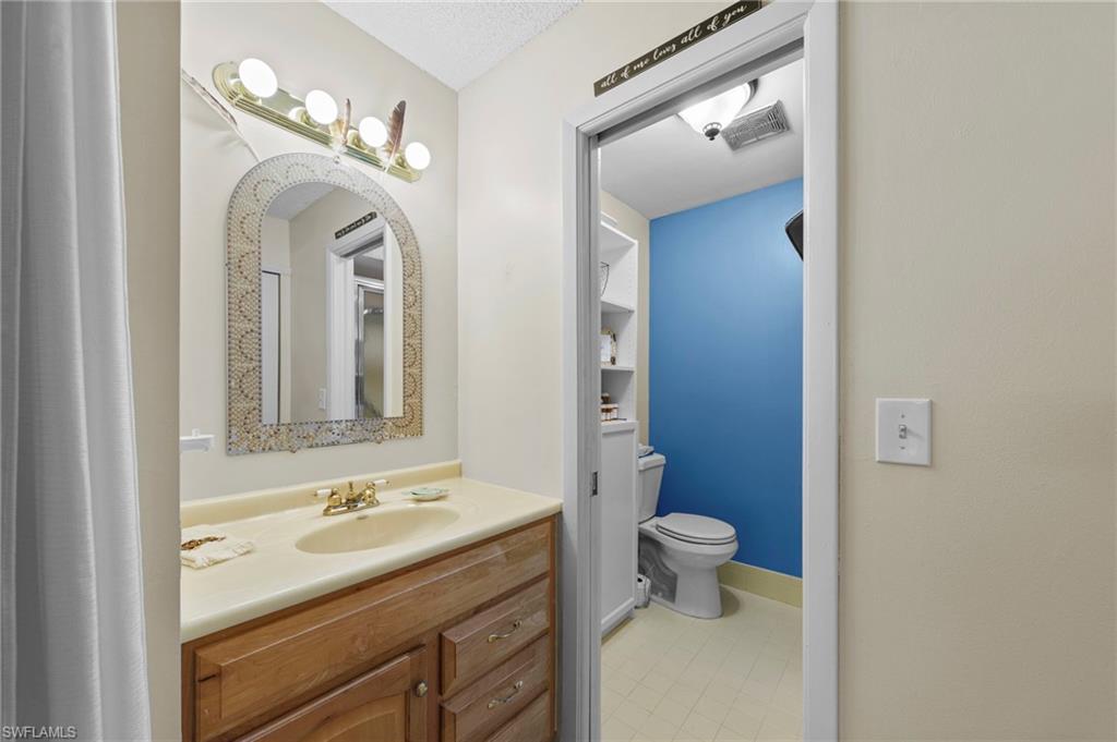 180 Harrison Road, Unit G4 Naples, FL 34112 - Photo 22 of 46 a bathroom with a toilet sink and mirror