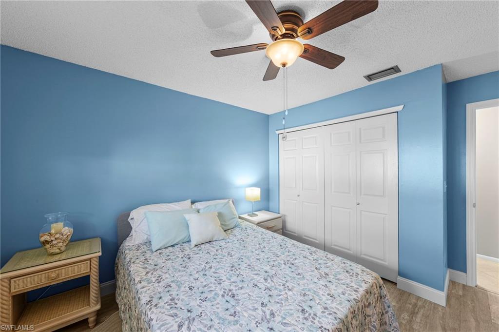 180 Harrison Road, Unit G4 Naples, FL 34112 - Photo 23 of 46 a bedroom with a bed and a chandelier