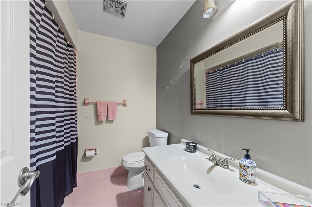 180 Harrison Road, Unit G4 Naples, FL 34112 - Photo 24 of 46 a bathroom with a sink a toilet and mirror