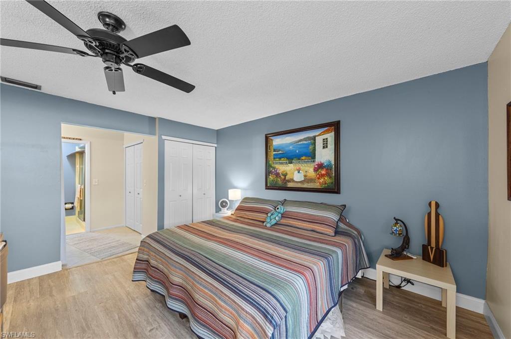180 Harrison Road, Unit G4 Naples, FL 34112 - Photo 26 of 46 a bedroom with a bed and a chandelier