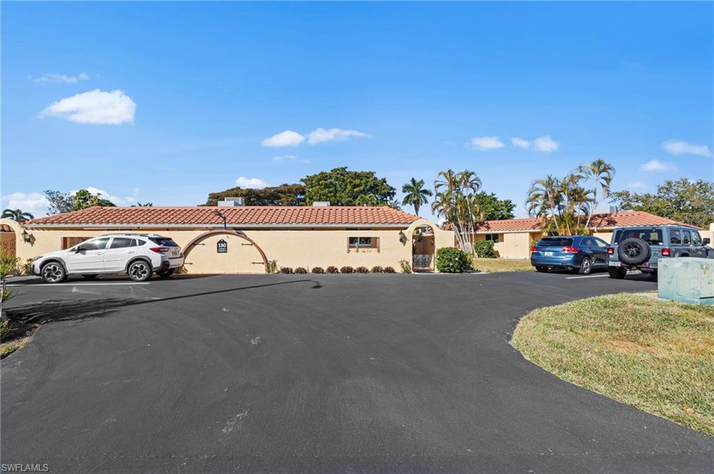 180 Harrison Road, Unit G4 Naples, FL 34112 - Photo 29 of 46 a view of building with parked cars