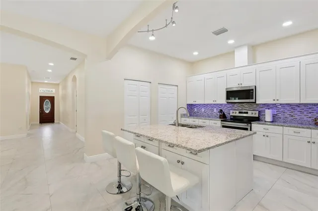 a spacious bathroom with a granite countertop sink a mirror and a shower