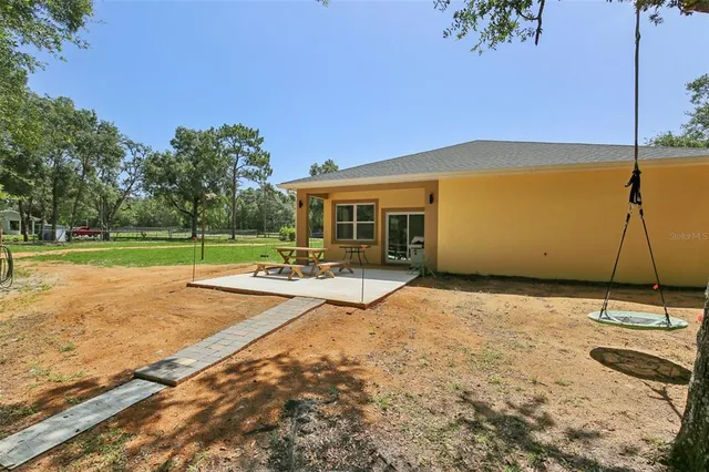 an aerial view of residential house with outdoor space and trees