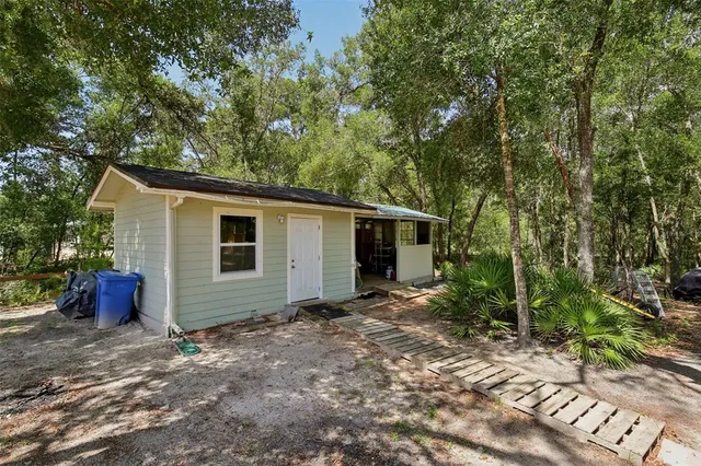 a front view of a house with a yard and trees