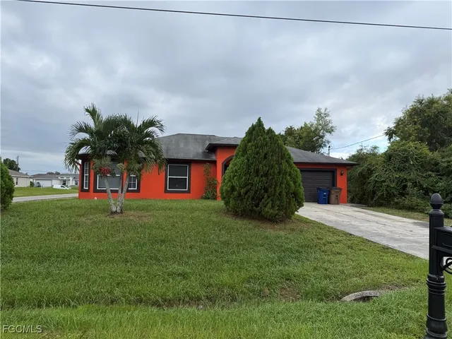 a front view of a house with a yard and trees