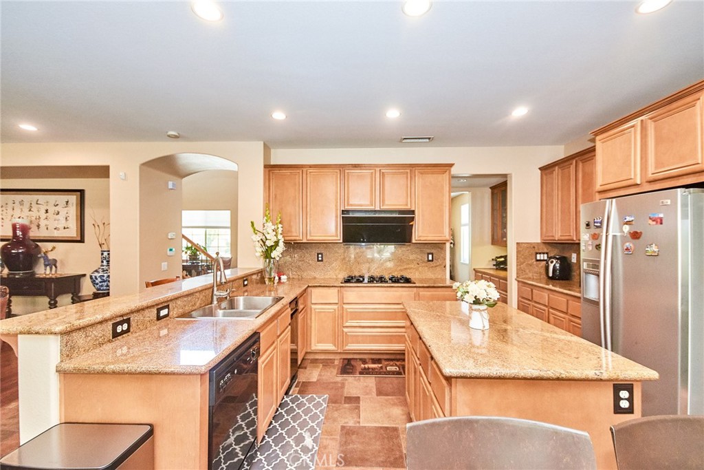 12430 Split Rein Drive Rancho Cucamonga, CA 91739 - Photo 14 of 29 a large kitchen with a large counter top appliances and cabinets