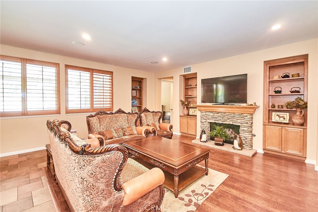 12430 Split Rein Drive Rancho Cucamonga, CA 91739 - Photo 18 of 29 a living room with furniture a fireplace with wooden floor