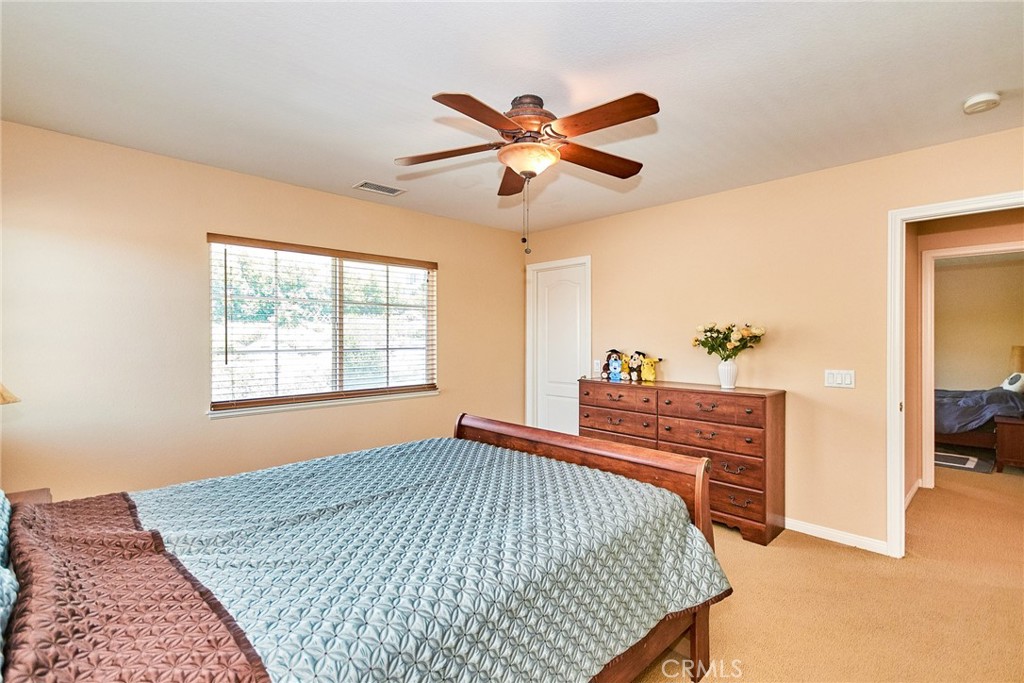 12430 Split Rein Drive Rancho Cucamonga, CA 91739 - Photo 22 of 29 a bedroom with a bed and a chandelier