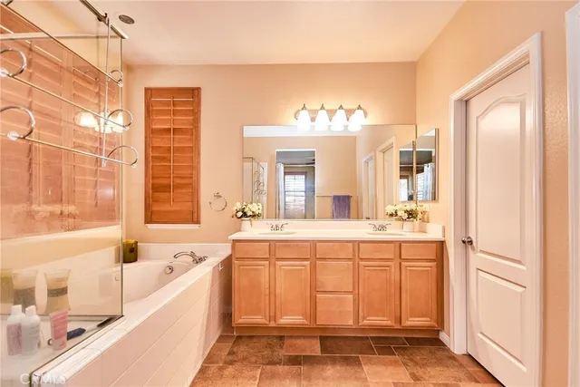 a spacious bathroom with a tub sink and mirror
