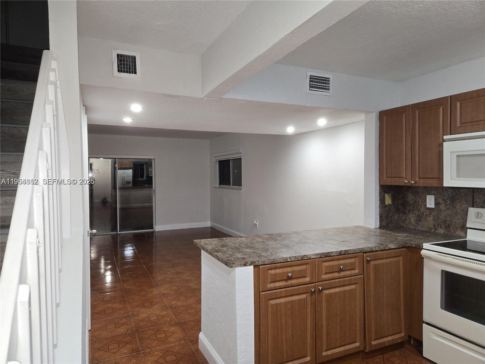 a kitchen with granite countertop a sink and cabinets