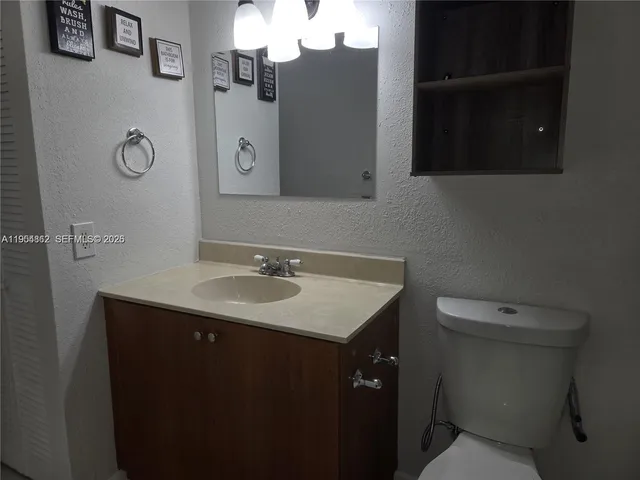 a bathroom with a sink toilet and mirror