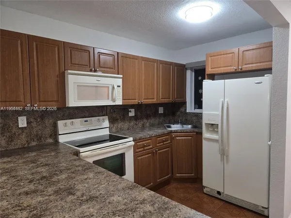 a kitchen with a refrigerator stove and sink