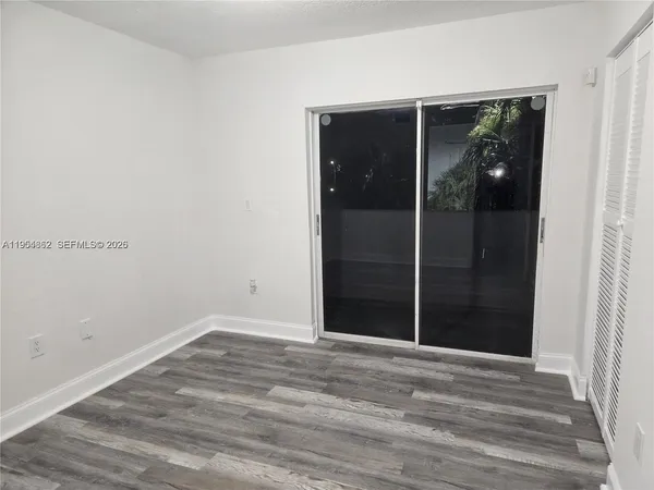 a view of an empty room with closet and mirror
