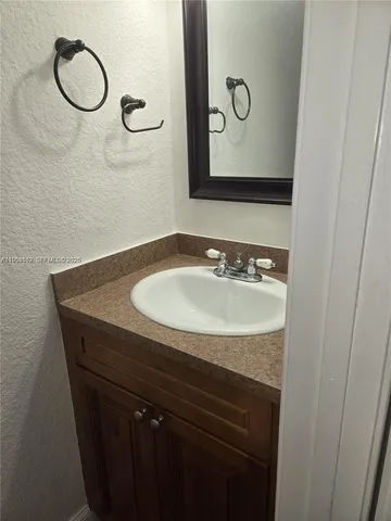 a bathroom with a granite countertop sink and a mirror