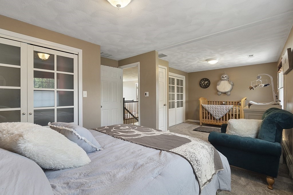 6 Violet Road Billerica, MA 01821 - Photo 25 of 42 a bedroom with a bed and wooden floor