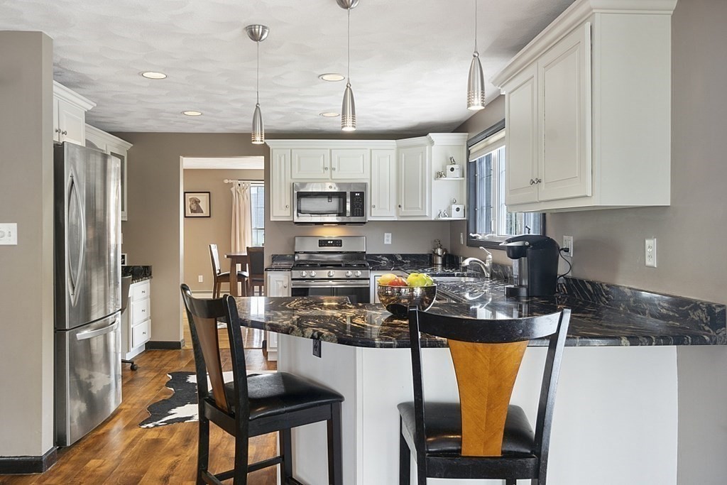 6 Violet Road Billerica, MA 01821 - Photo 10 of 42 a kitchen with stainless steel appliances granite countertop a stove a refrigerator a sink a stove and white cabinets with wooden floor