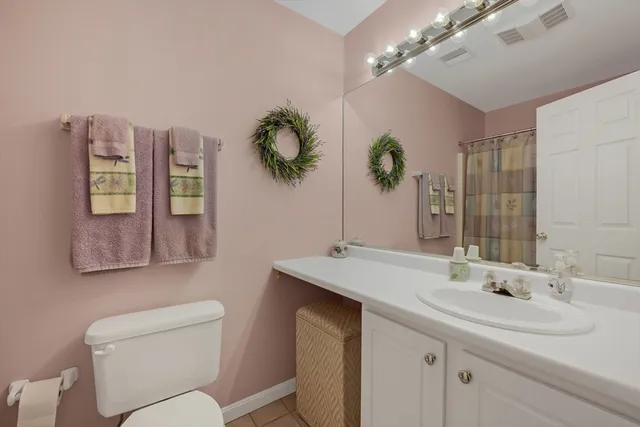 a bathroom with a toilet a sink and mirror