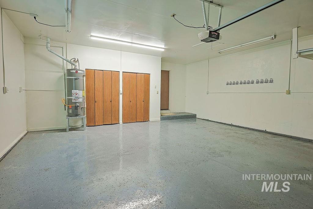 640 Morrison Street Twin Falls, ID 83301 - Photo 27 of 30 Spacious garage featuring a durable epoxy floor coating, two sets of bi-fold wooden doors, overhead fluorescent lighting, and a garage door opener mechanism