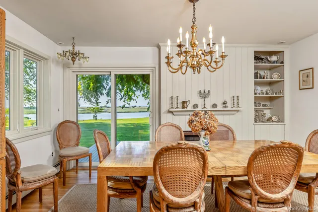 a dining room with furniture a chandelier and wooden floor