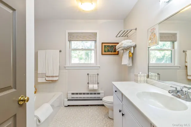 a bathroom with a sink mirror and a window