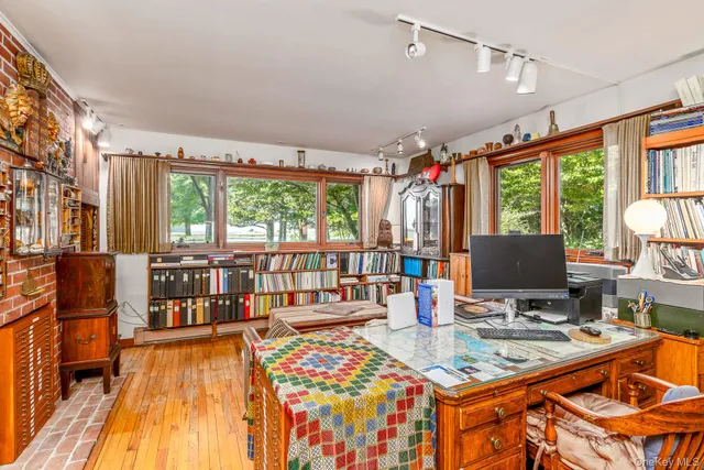 a living room with furniture a flat screen tv and floor to ceiling windows