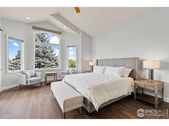 a bedroom with a bed a couch and large window