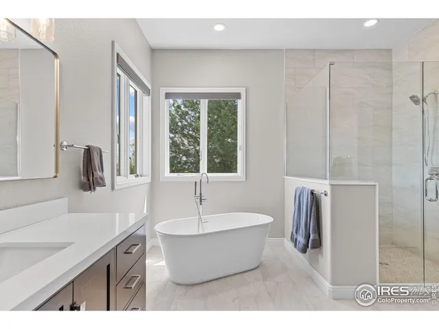 a bathroom with a tub sink and mirror