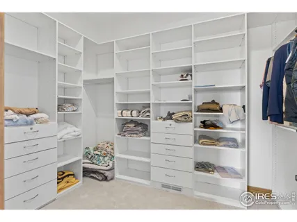 a view of walk in closet with clothes and shoes