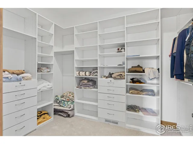 a view of walk in closet with clothes and shoes
