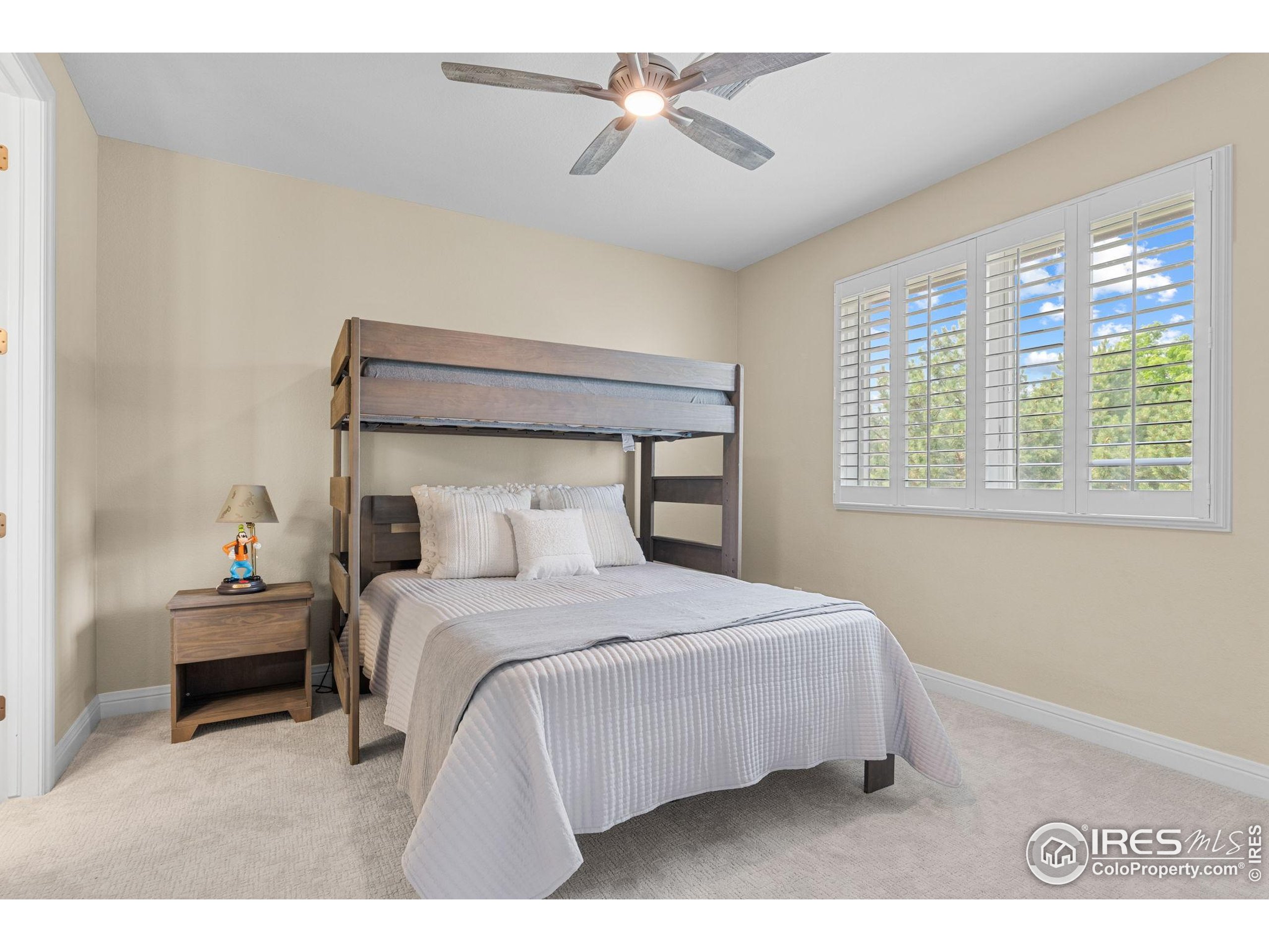 6557 Legend Ridge Trail Niwot, CO 80503 - Photo 26 of 42 a bedroom with a bed a chandelier and a window