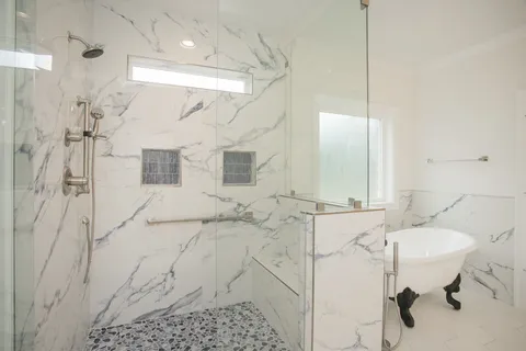 a bathroom with a sink shower and a mirror
