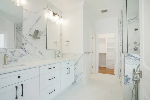 a spacious bathroom with double vanity sink and shower