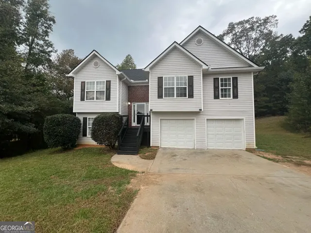 a view of house with yard and garage
