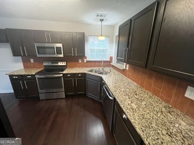 a kitchen with stainless steel appliances granite countertop a sink stove and refrigerator