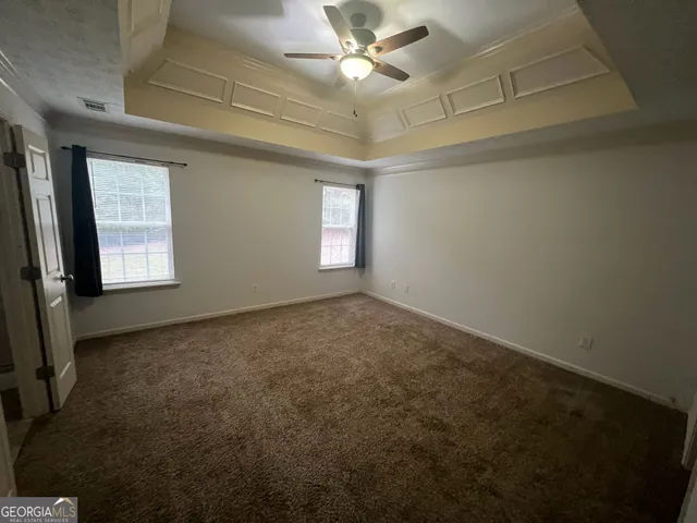 en empty room with windows and ceiling fan