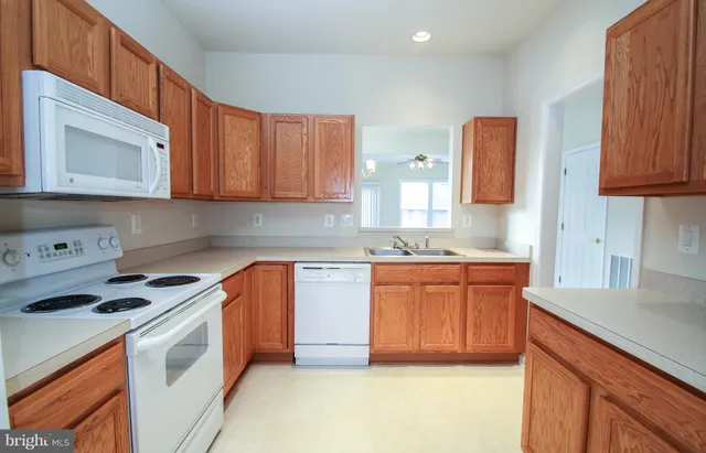 a kitchen with granite countertop a sink stove and cabinets