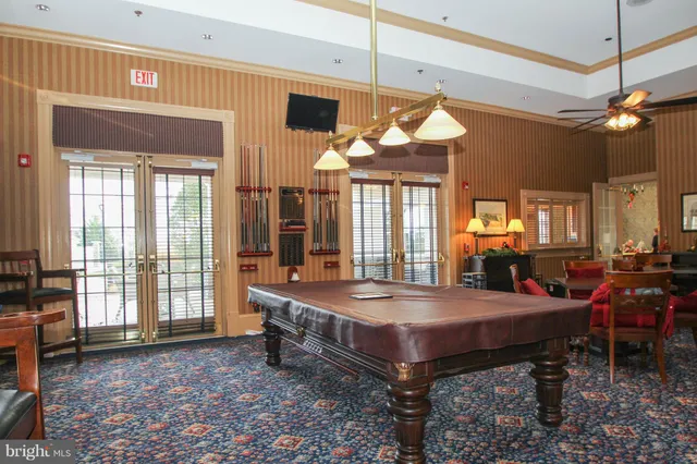 a room with pool table and large windows