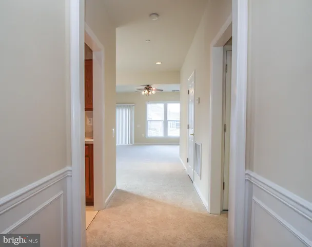 a view of a hallway with wooden shelves