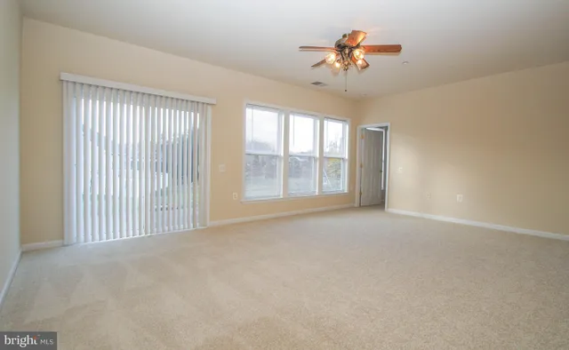 a view of a livingroom with a ceiling fan and window