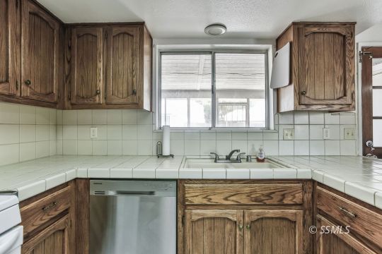 604 South Lakeview Court Ridgecrest, CA 93555 - Photo 11 of 29 a kitchen with stainless steel appliances granite countertop a sink stove and cabinets