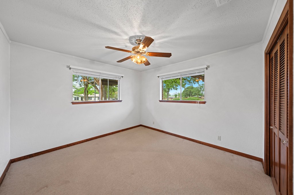 133 Oak Way Kerrville, TX 78028 - Photo 13 of 26 an empty room with windows and fan
