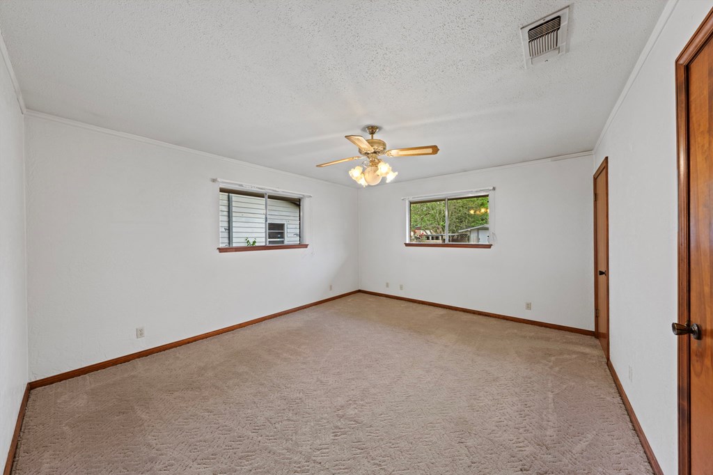 133 Oak Way Kerrville, TX 78028 - Photo 16 of 26 an empty room with windows and chandelier fan