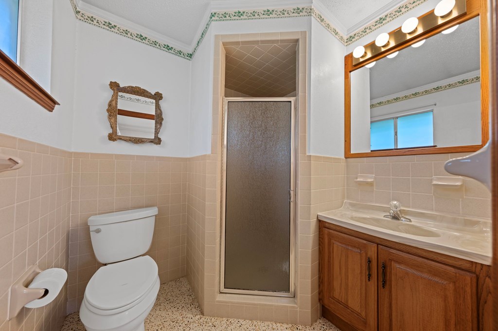 133 Oak Way Kerrville, TX 78028 - Photo 18 of 26 a bathroom with a toilet sink and mirror